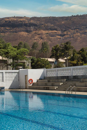 Private swimming pool shimmering under a clear blue sky with mountain views