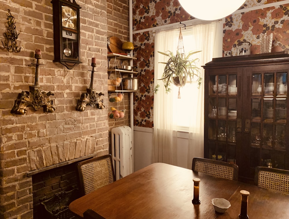 a dining room with a brick wall and a wooden table