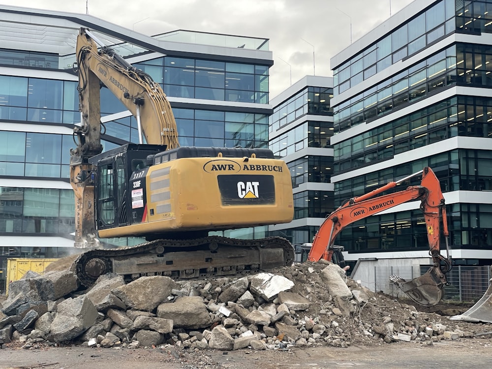 a bulldozer digging through a pile of rubble in front of a building
