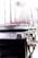 A close-up view of a metallic cylindrical appliance with a transparent section at the top containing small red objects. The appliance has a shiny, reflective metal surface with a knob on the side, suggesting it might be used for cooking or processing food.