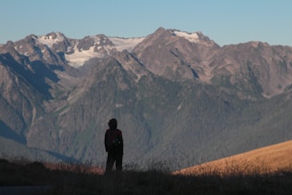 A rugged mountaineering backpack resting against a rocky mountain trail under a clear sky.