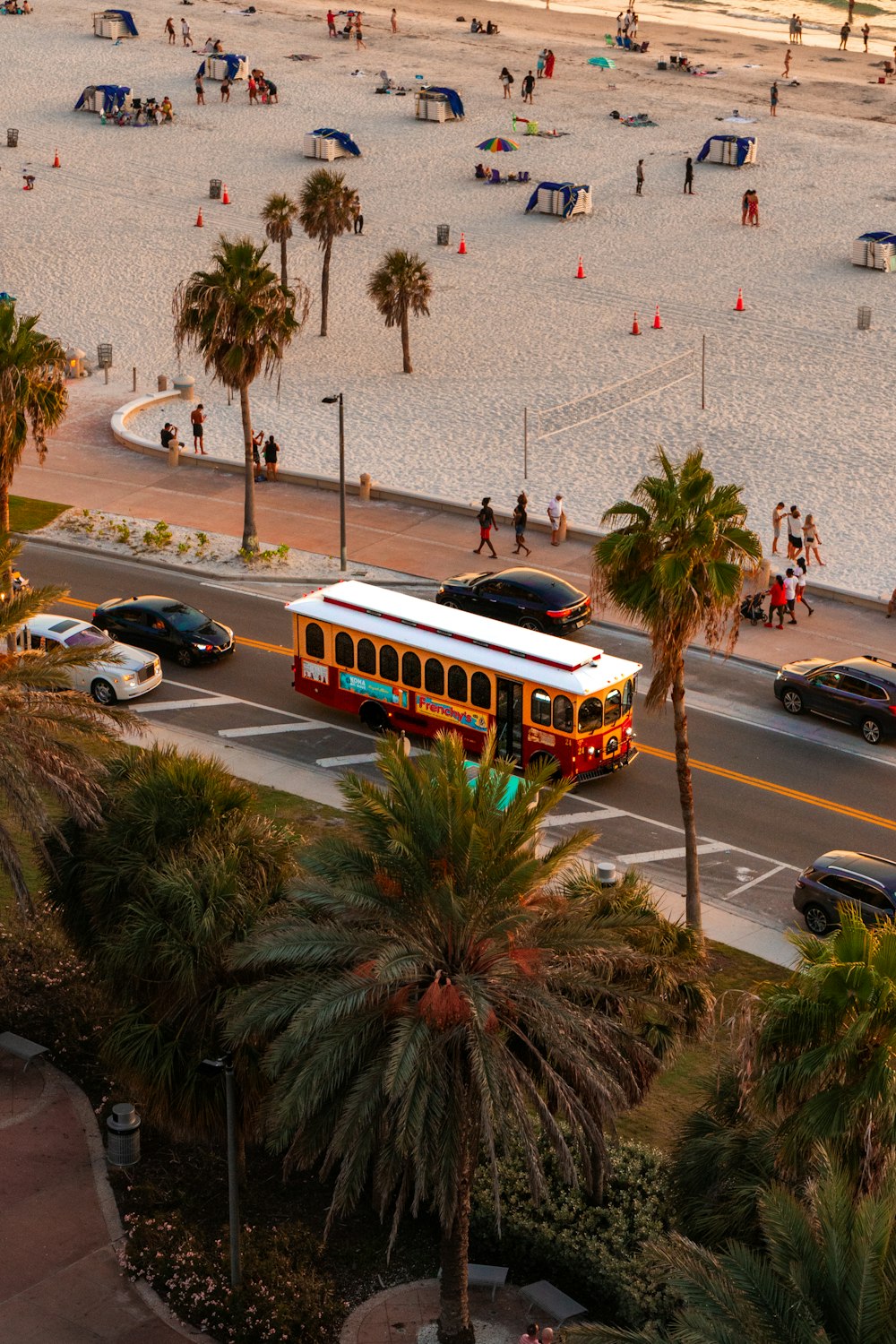 a bus driving down a street next to a beach