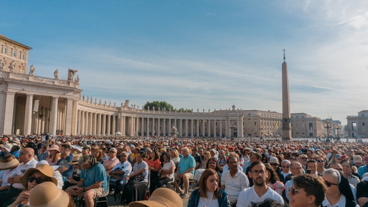 a large group of people standing in St. Peter's Square in Vatican City