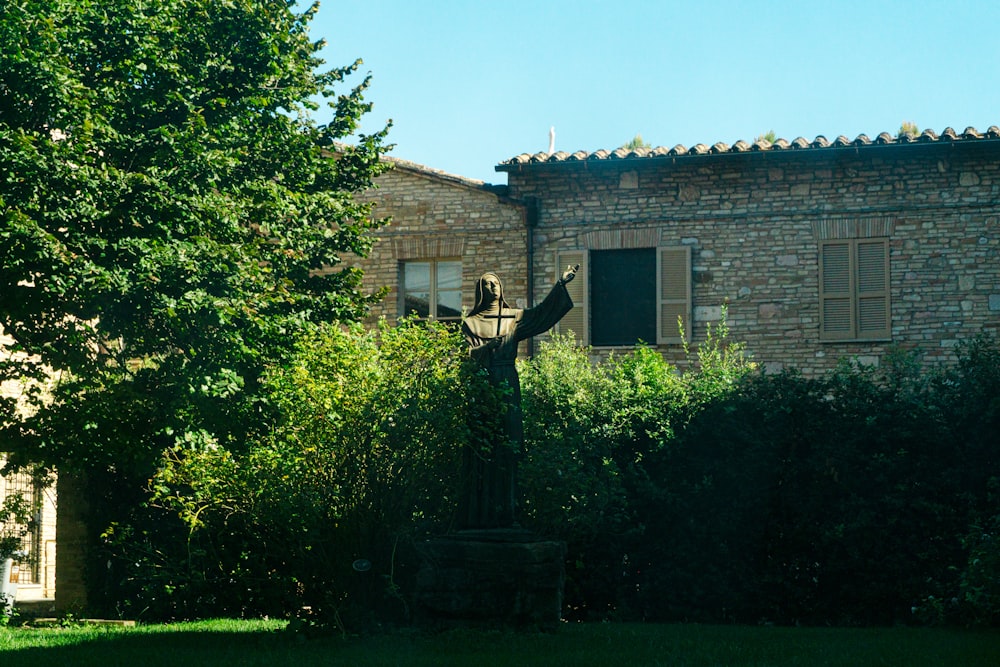 a statue of a bird in front of a brick building