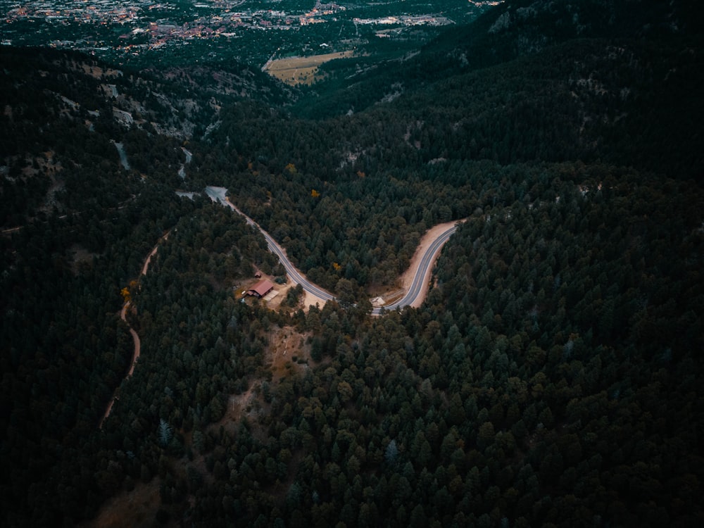 an aerial view of a road in the middle of a forest