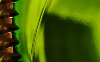 Automated capping machine sealing bottles with metal caps under bright factory lights.