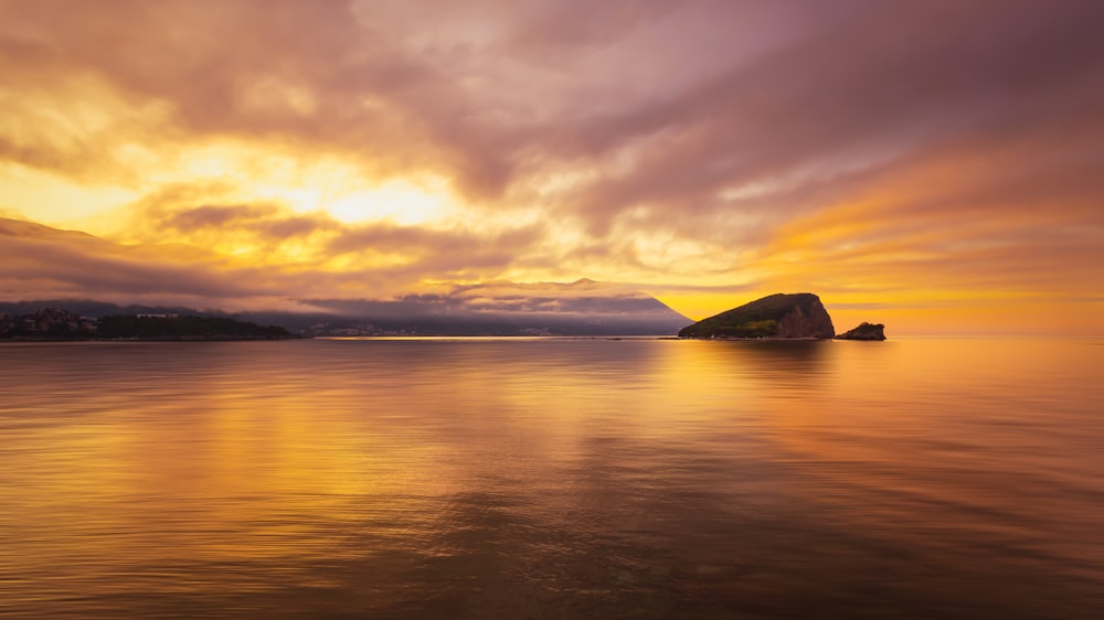 a large body of water under a cloudy sky