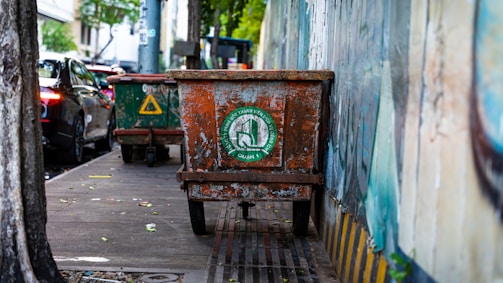 Workers installing metal trash bins along a city sidewalk.