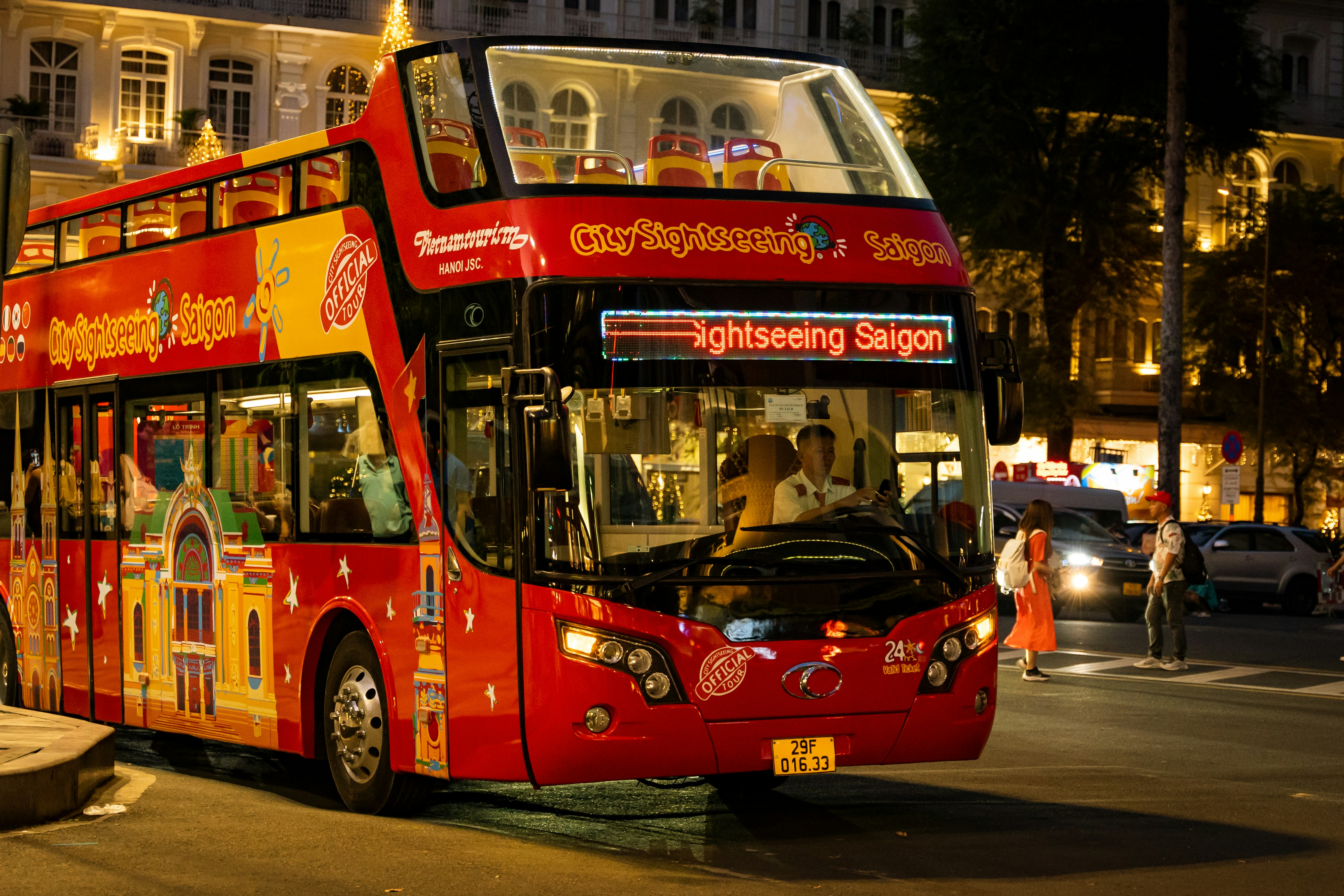 a red double decker bus driving down a street