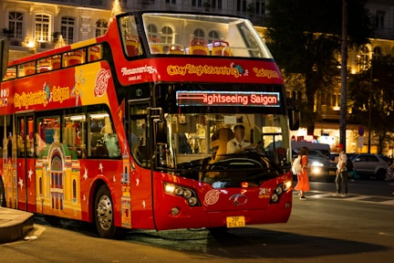 a red double decker bus driving down a street