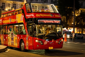 a red double decker bus driving down a street