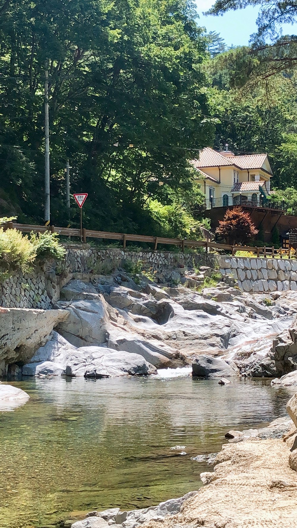 a house sitting on top of a hill next to a river