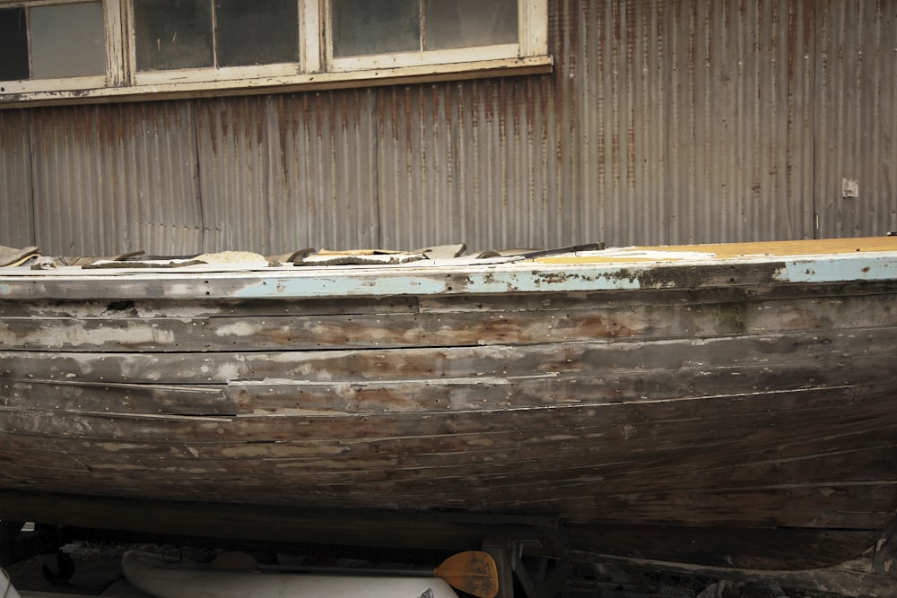an old wooden boat sitting in front of a building