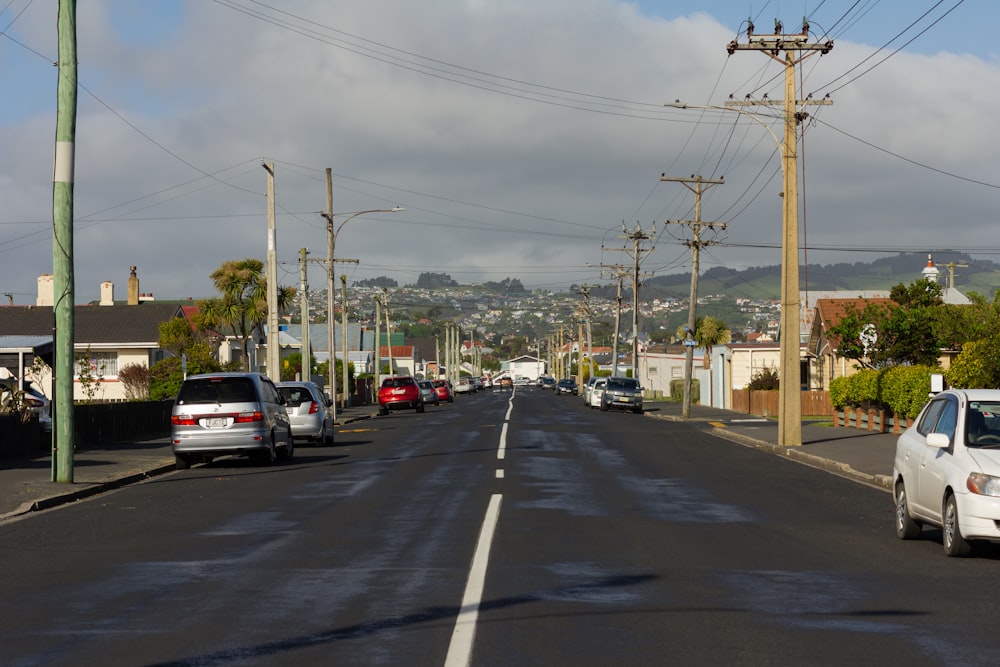 a street lined with parked cars and telephone poles