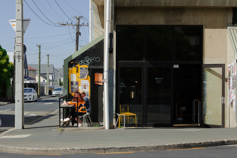 a person sitting at a table in front of a building