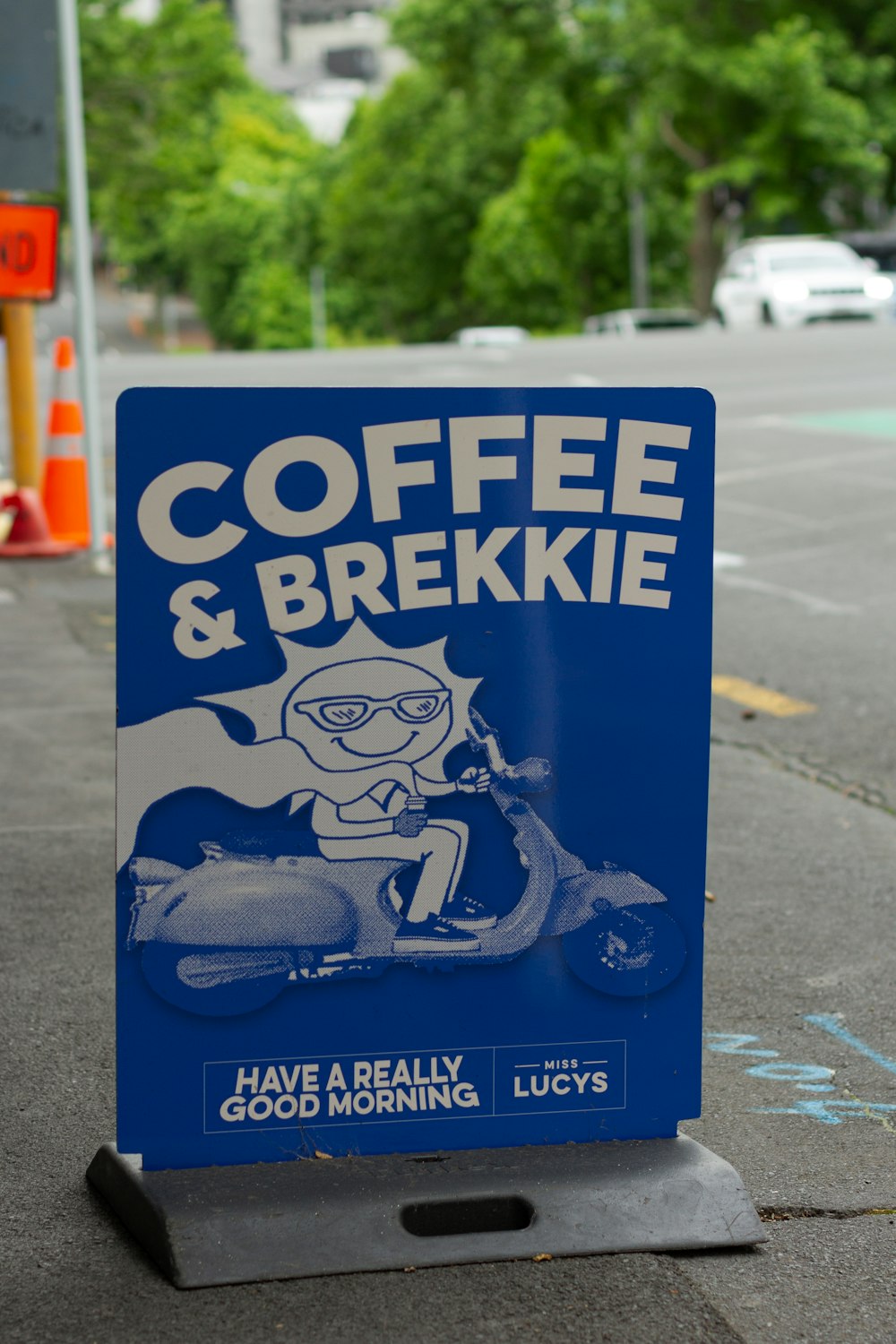 a coffee and brekie sign on the side of the road