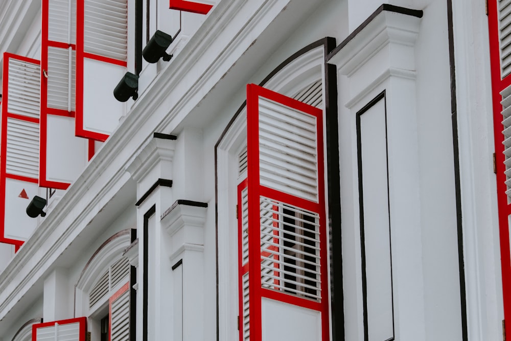 a red and white building with shutters and windows