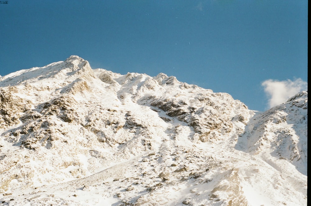 una montaña cubierta de nieve con un cielo azul en el fondo