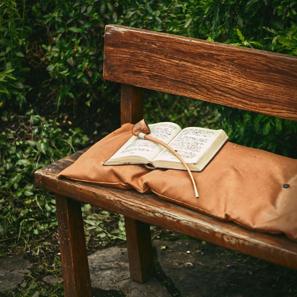 a book on a pillow on a wooden bench