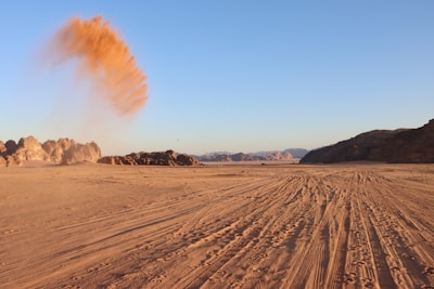 A close-up of a dusty tire track leading into the vast Namibian wilderness.