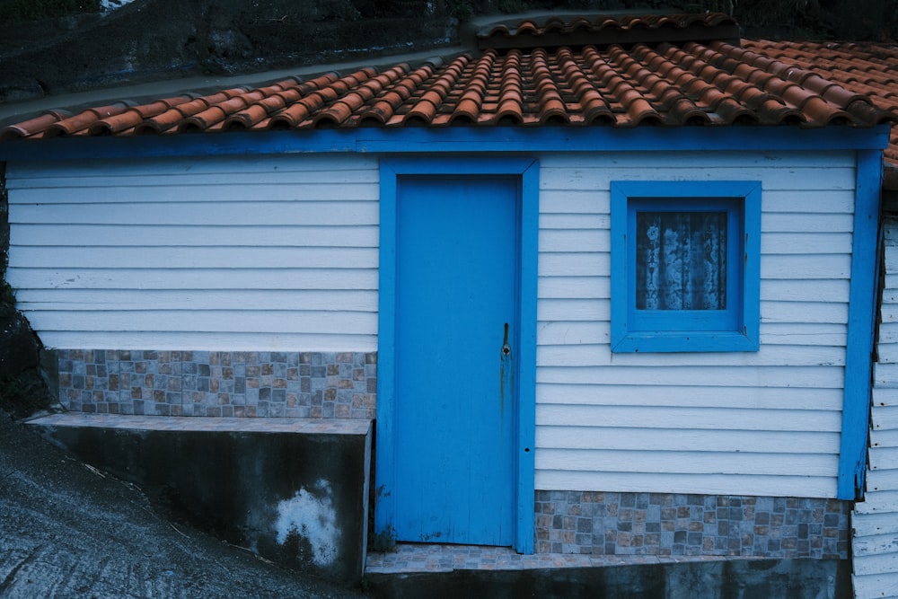 a small white house with a blue door