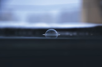 Close-up of a clear bubble level tool resting on a wooden surface, highlighting the bubble inside the vial.
