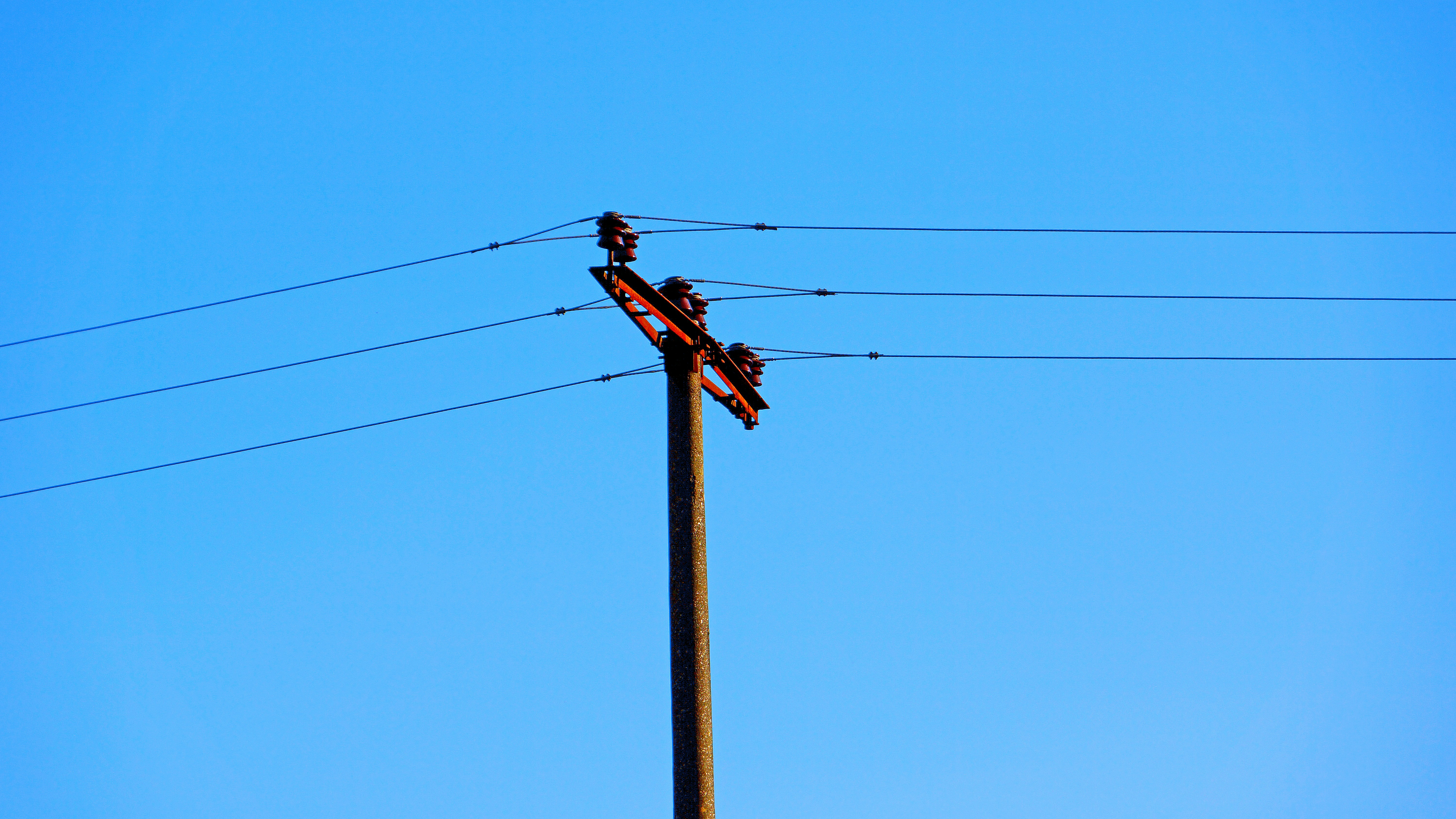 a telephone pole with two birds sitting on top of it