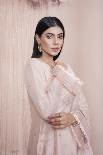 A sleek, minimalistic 3D render of a traditional embroidered long shirt in dark champagne tones.