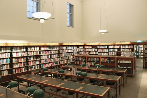 a library filled with lots of tables and chairs