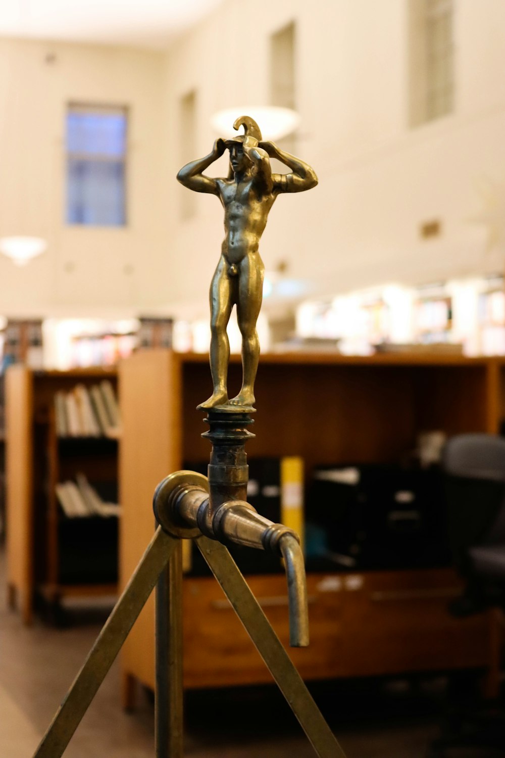 a statue of a man standing on top of a metal pole