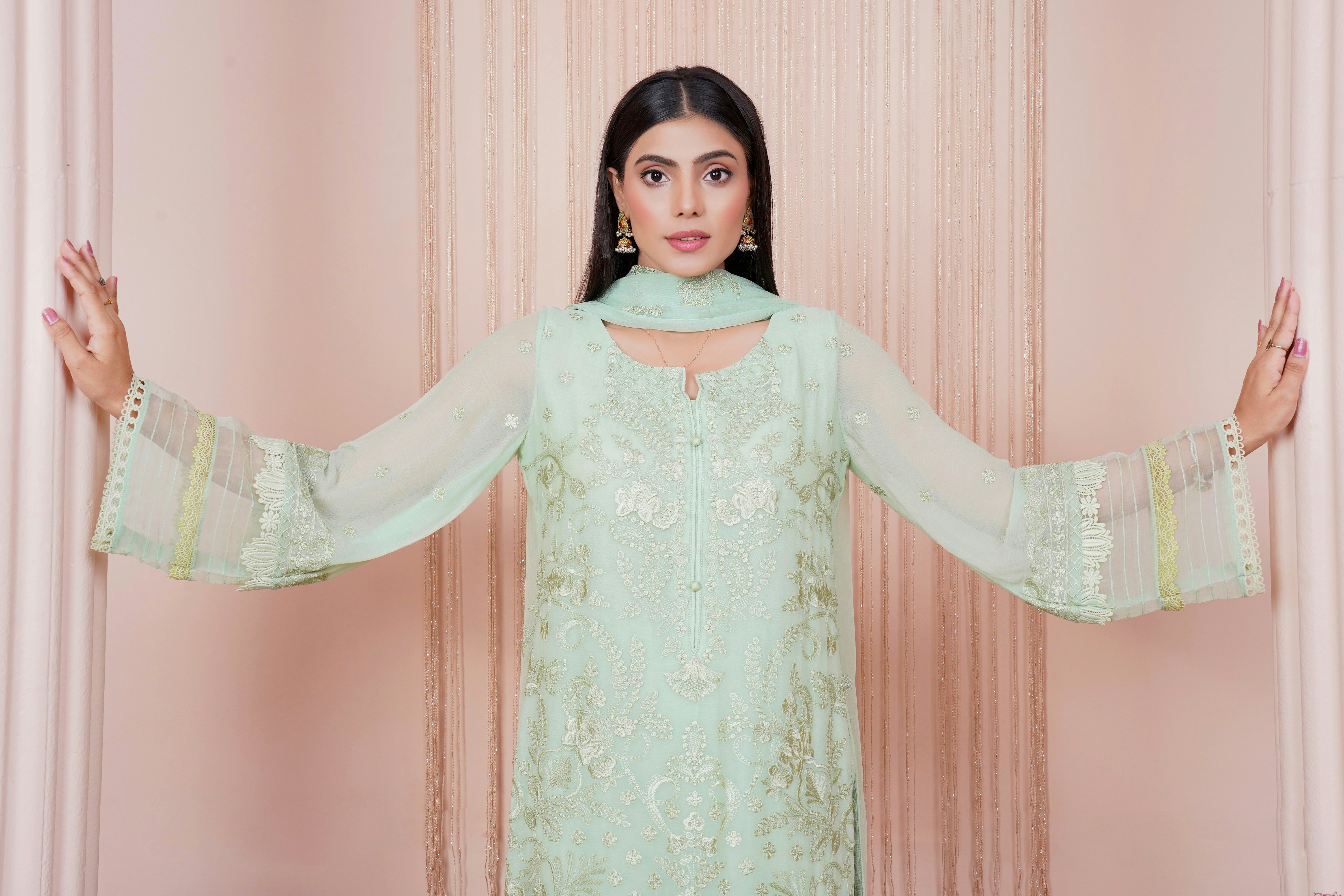 a woman in a green dress with her arms outstretched