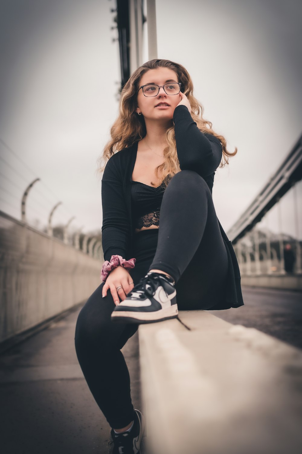 a woman sitting on a ledge with her legs crossed