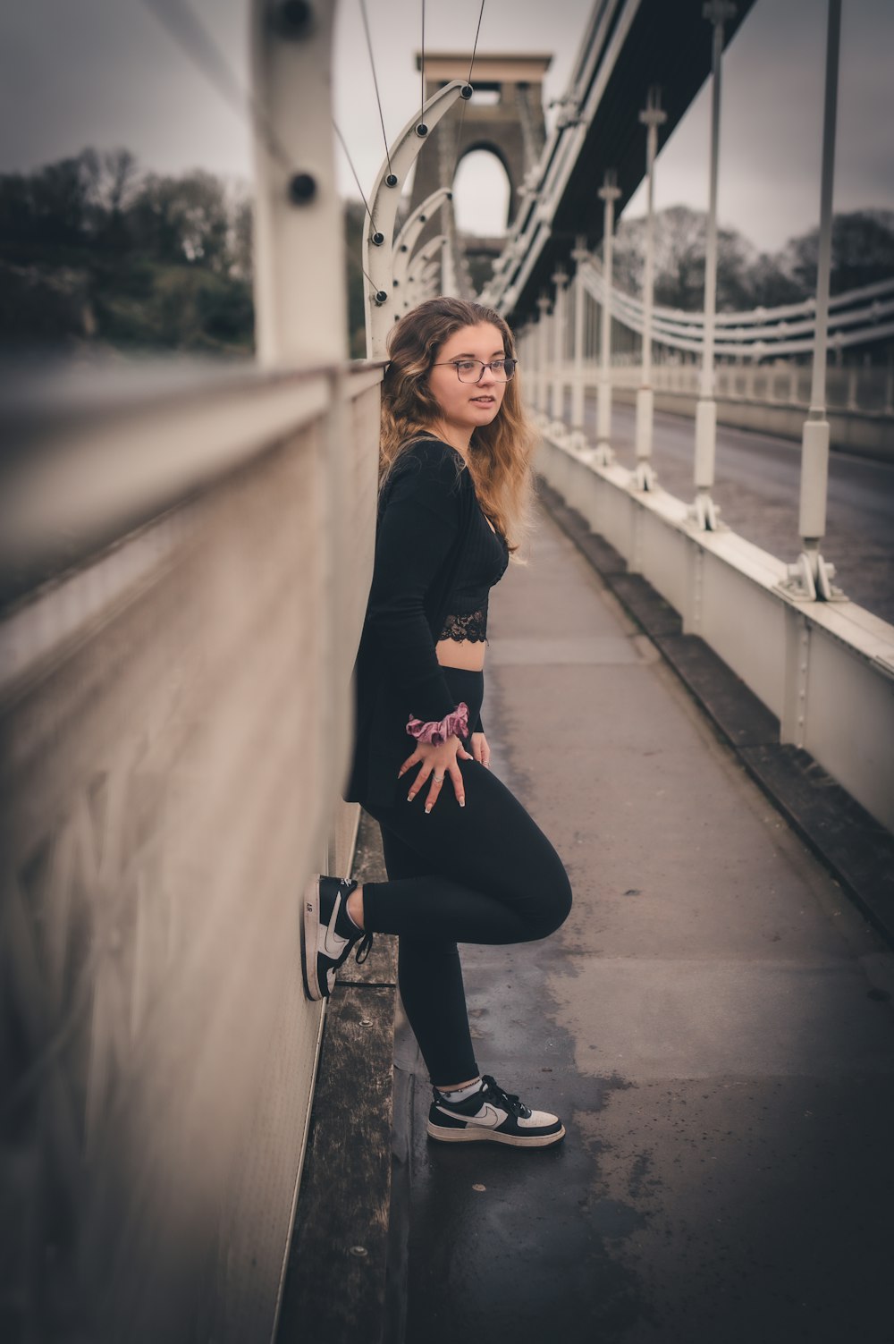 a woman standing on a bridge posing for a picture