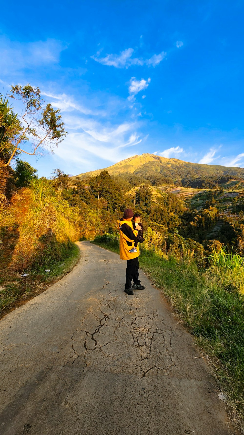 a man standing on a dirt road holding a camera