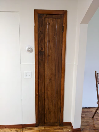 Close-up of the room door with a warm wooden finish.