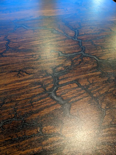 A close-up of a handcrafted botanical pattern etched into a polished wood surface, highlighting fine details and natural textures.