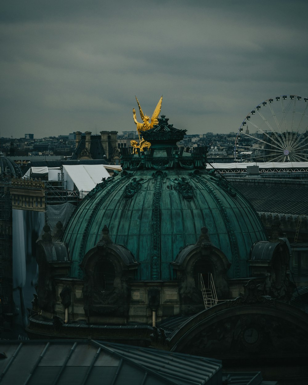 a green dome with a gold statue on top of it