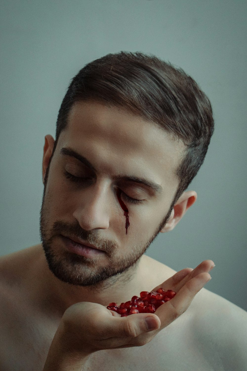 a man holding a handful of pomegranate in his hands