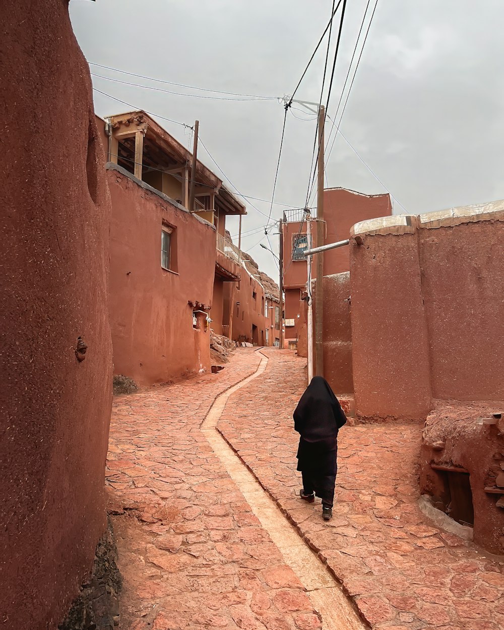 a person walking down a cobblestone street