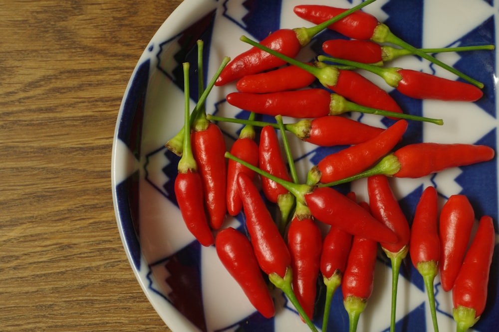 a bunch of red peppers on a blue and white plate