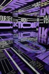 A visually striking room filled with mirrored surfaces reflecting large, bold text in purple and white. The text covers the walls, ceiling, and floor, creating an immersive and repetitive visual effect. The reflections and lighting add a sense of infinity and depth to the space.