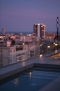 Rooftop pool overlooking the skyline during sunset.