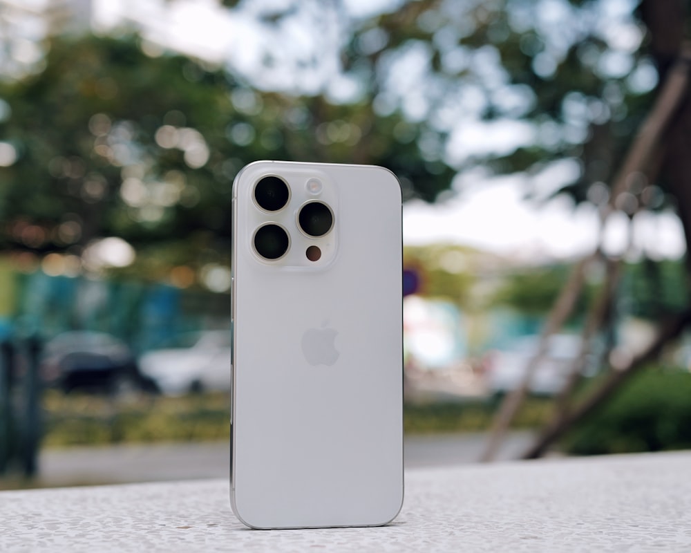 a white iphone sitting on top of a table