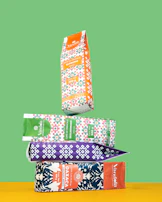 Vibrant packaging of Quinta Brisa coffee bags arranged on a wooden table with traditional Mexican textiles.