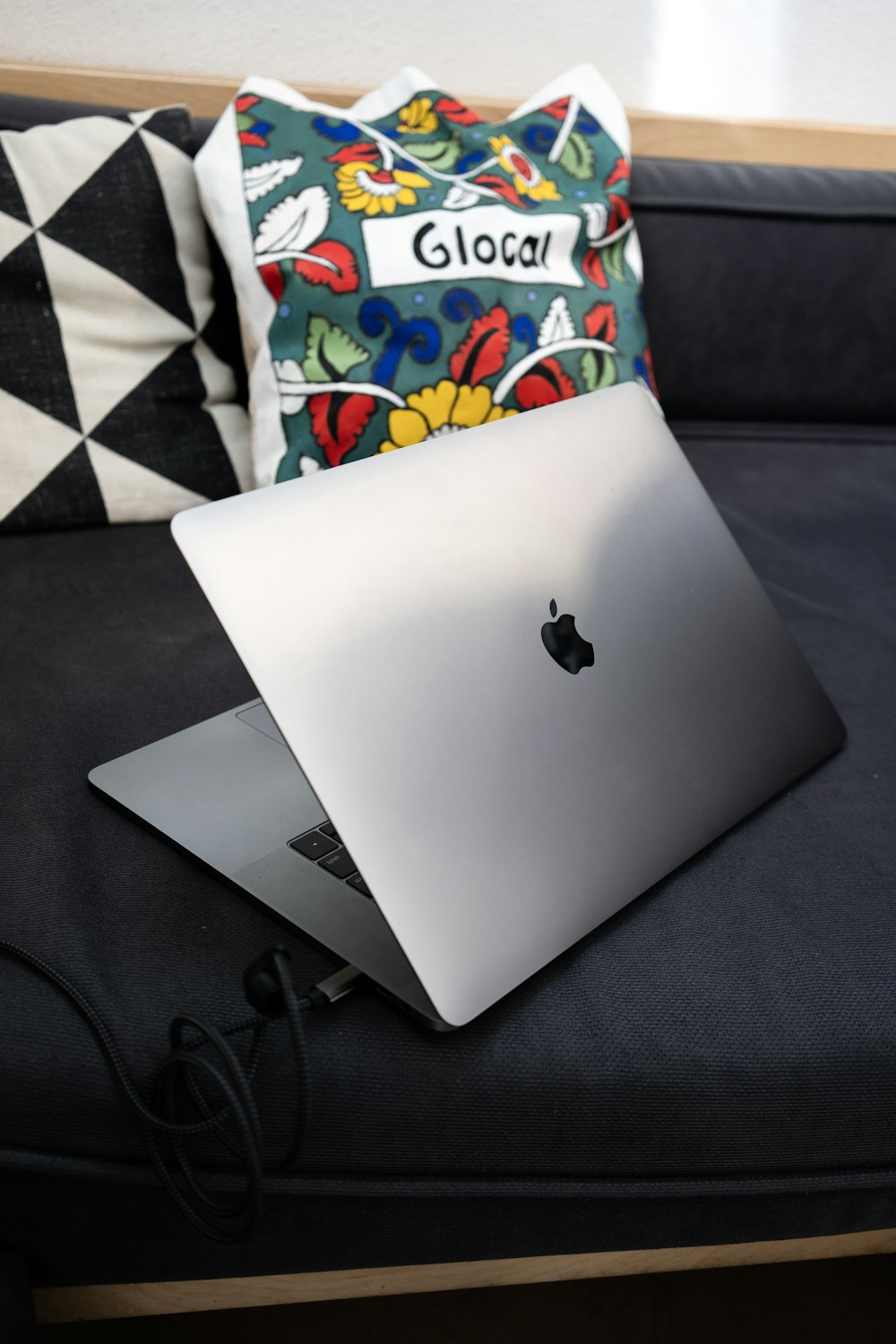 a laptop computer sitting on top of a black couch