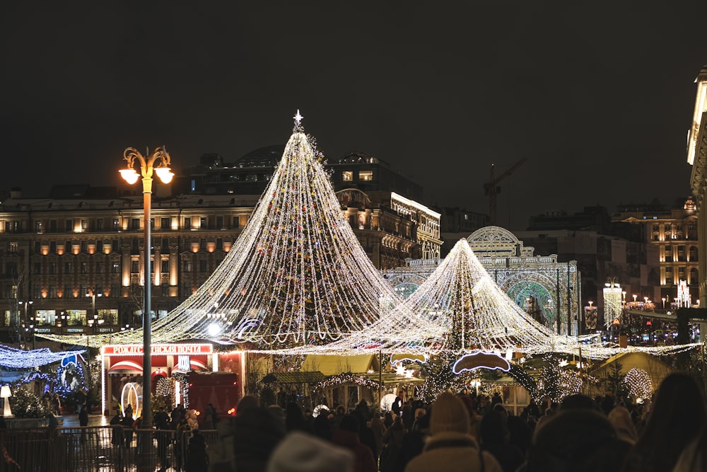 a crowd of people standing around a christmas tree