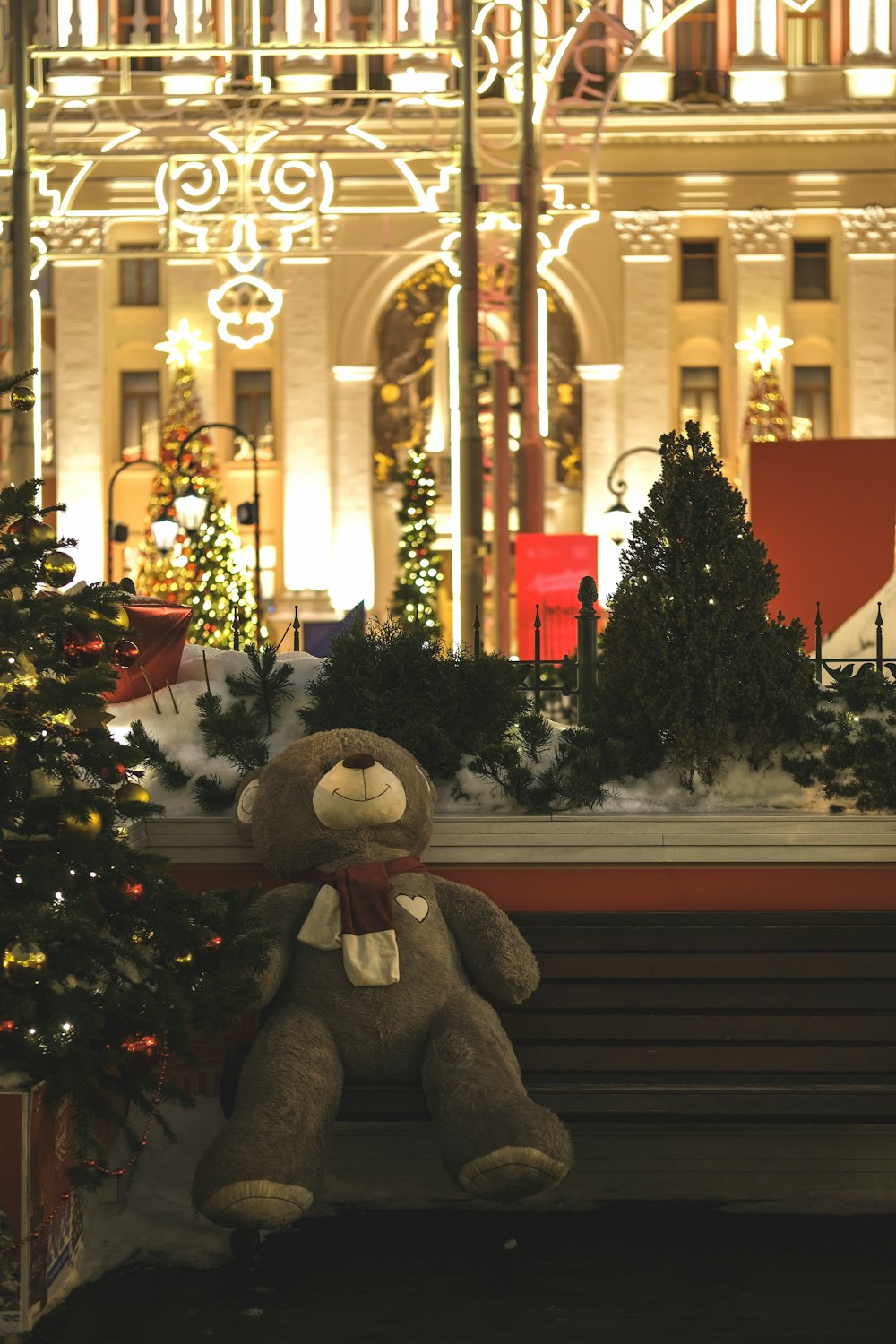 a teddy bear sitting on a bench in front of a building