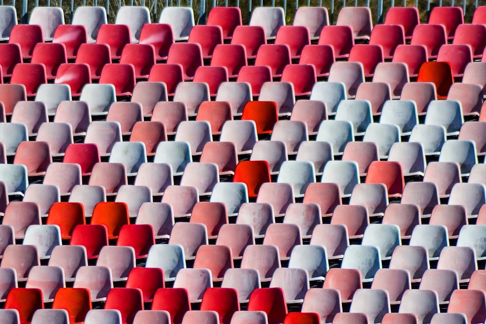 Reihen roter und weißer Stühle in einem Stadion