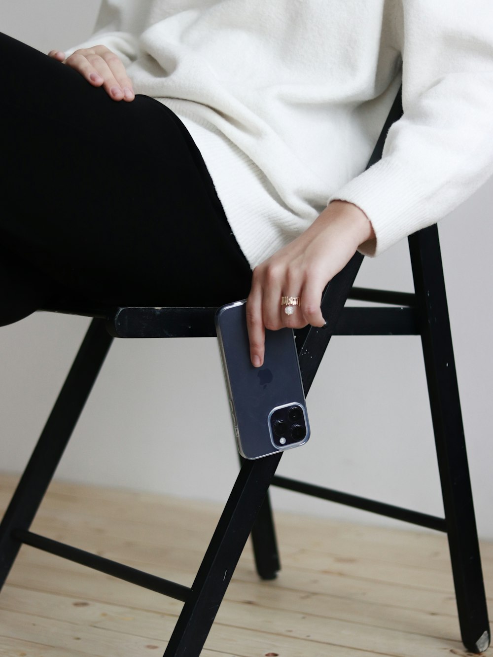 a woman sitting on a chair holding a cell phone