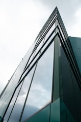 a tall glass building with a sky background